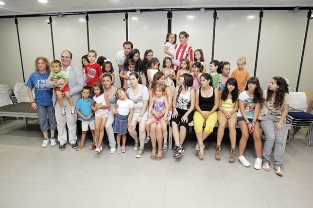 Foto de familia de Rosa Romero con los monitores y los niños. Tomás Fdez. de Moya