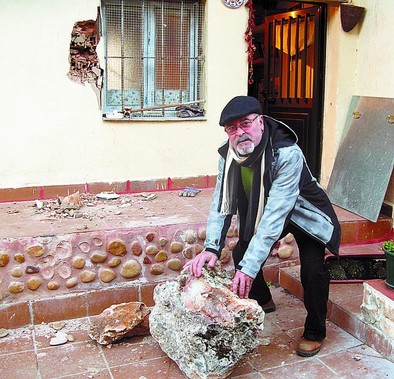 José R. Ramos muestra una de las piedras que impactó en su vivienda.  M.J.F.