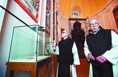 El prior del convento y otro monje -ceramista- observan las vitrinas vacías tras el robo del domingo. DB/Luis López Araico