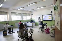 Imagen de archivo de un aula con alumnos y su profesora