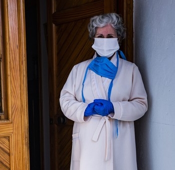 Una mujer, en el umbral de la puerta de su domicilio